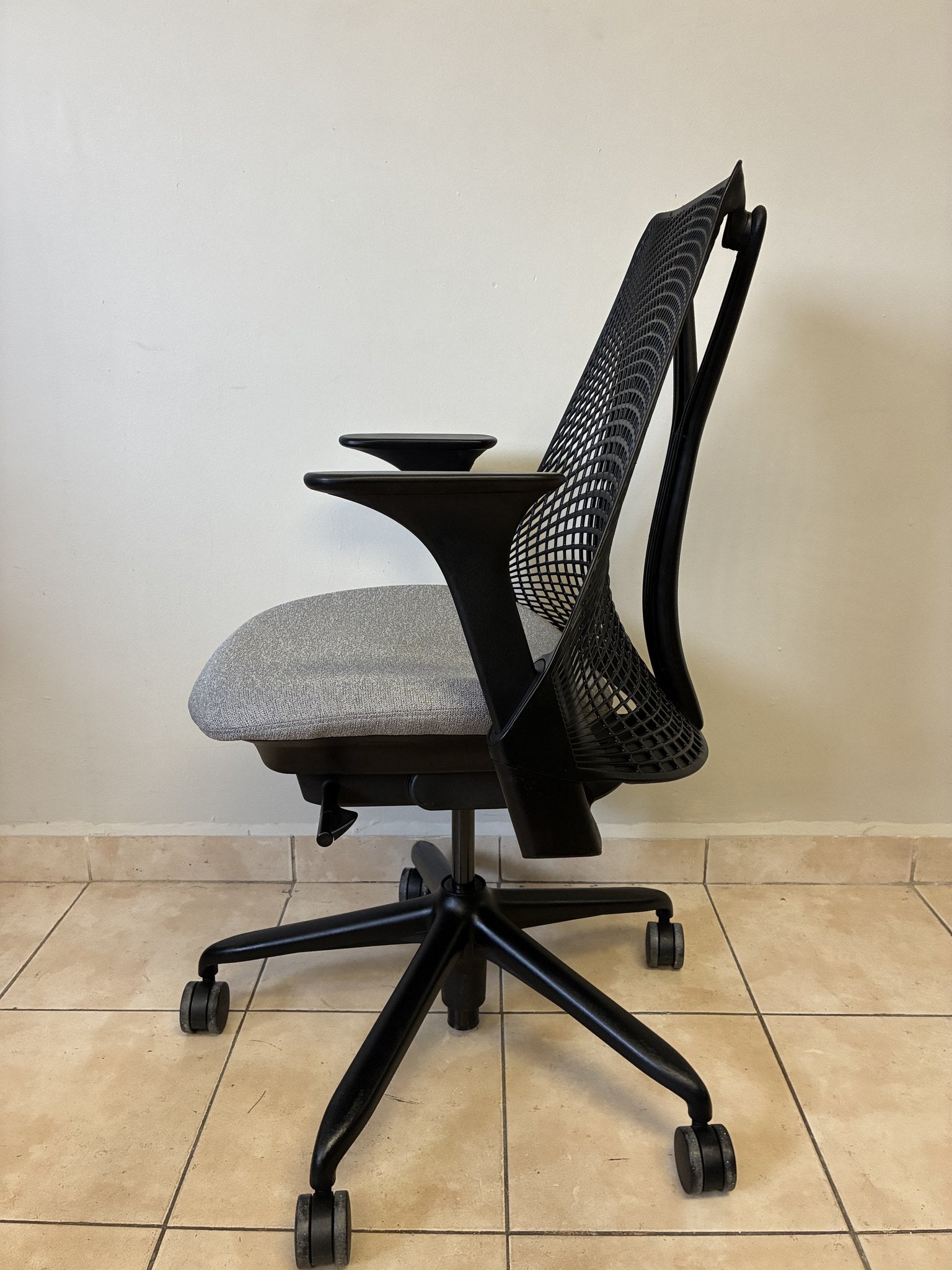 Silla de oficina Herman Miller Sayl pre-owned, respaldo negro y asiento gris, vista lateral.