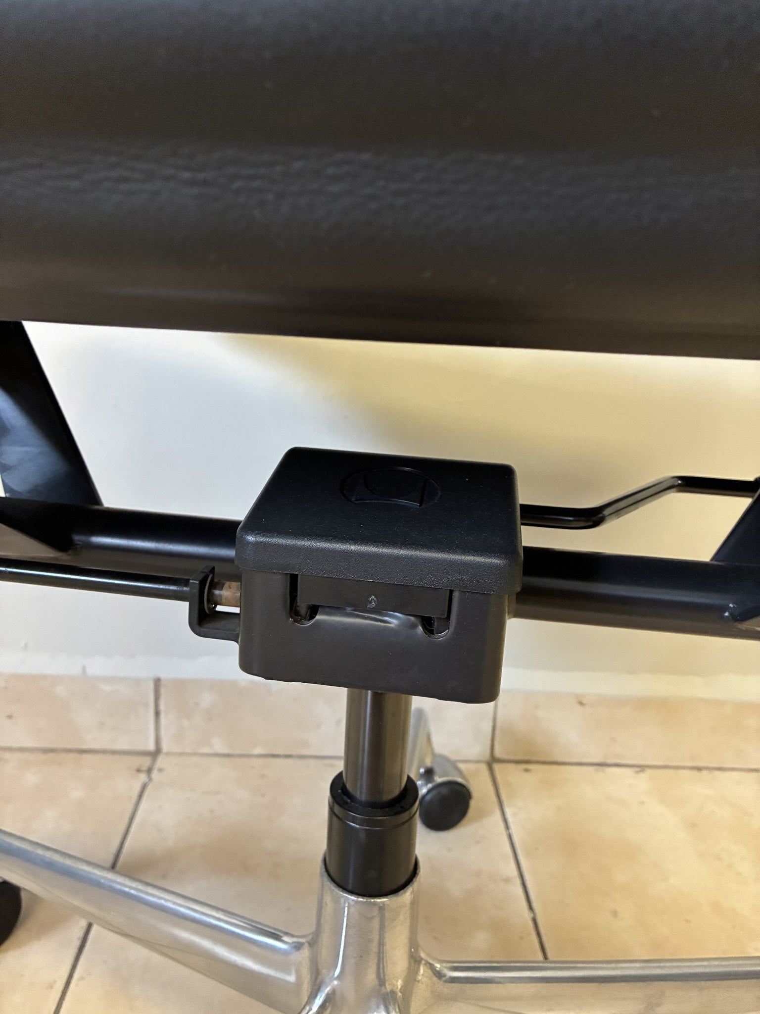 Silla ergonómica Herman Miller Eames de piel negra, vista de cerca de la base y el mecanismo de ajuste.