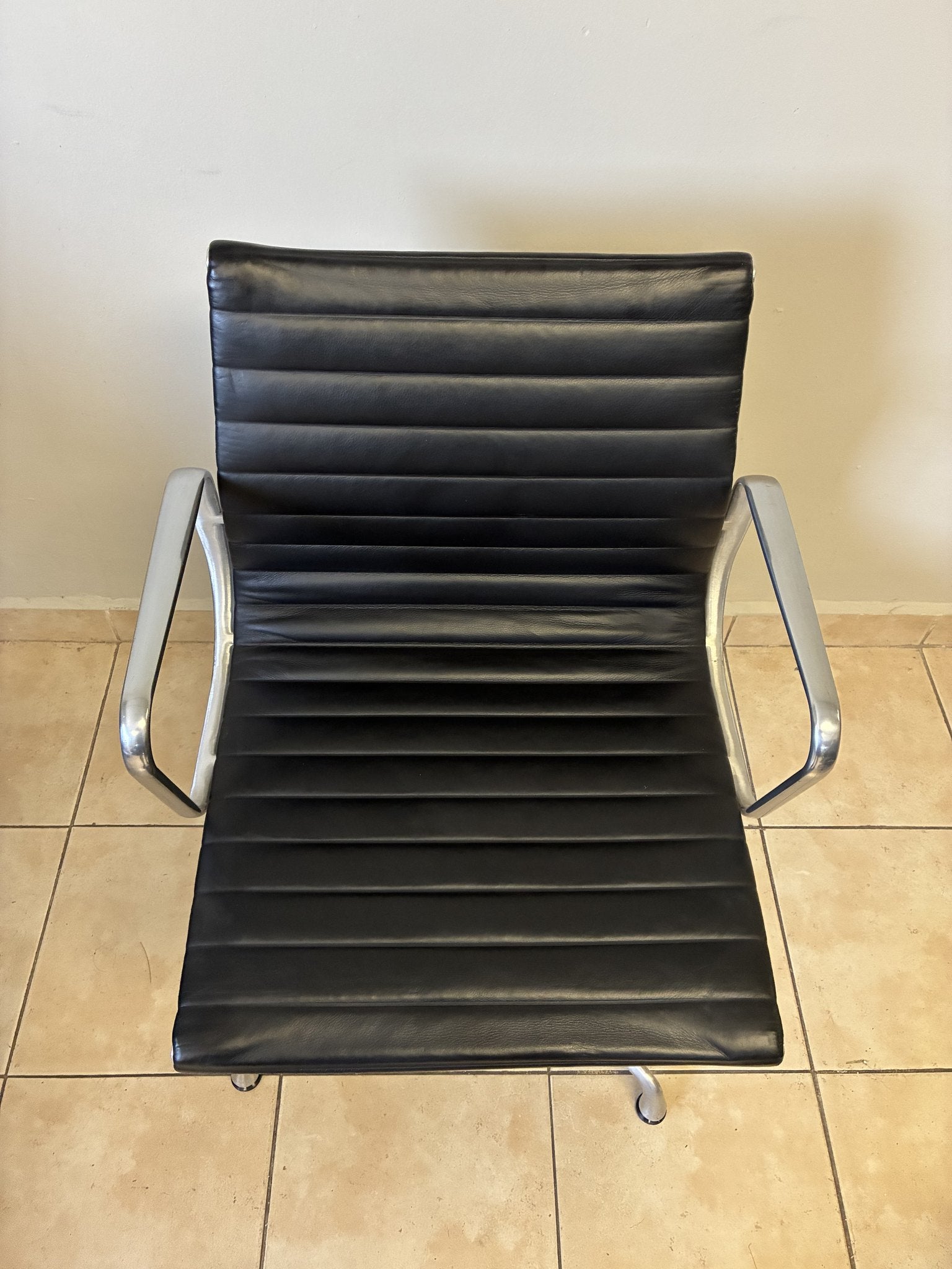Silla Eames Herman Miller fija preowned de piel negra, vista superior frontal. Diseño clásico con estructura cromada.
