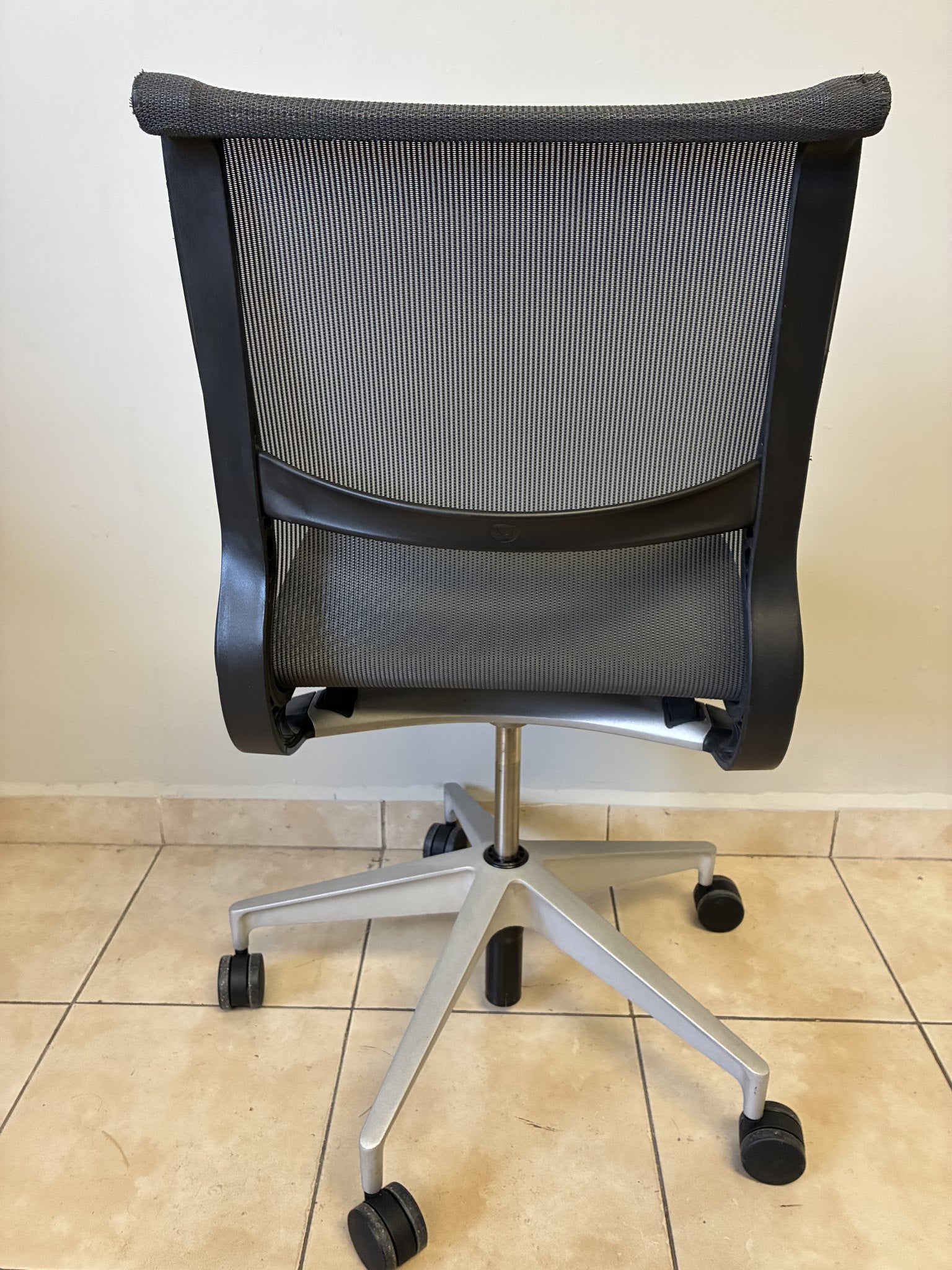 Silla de oficina Herman Miller Setu preowned, color gris oscuro, sin brazos, vista trasera completa.