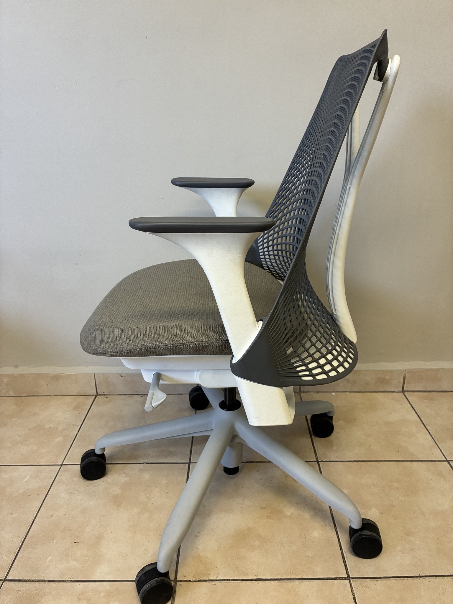Silla de oficina Herman Miller Sayl preowned, con respaldo de malla gris, asiento gris y base blanca, vista lateral.
