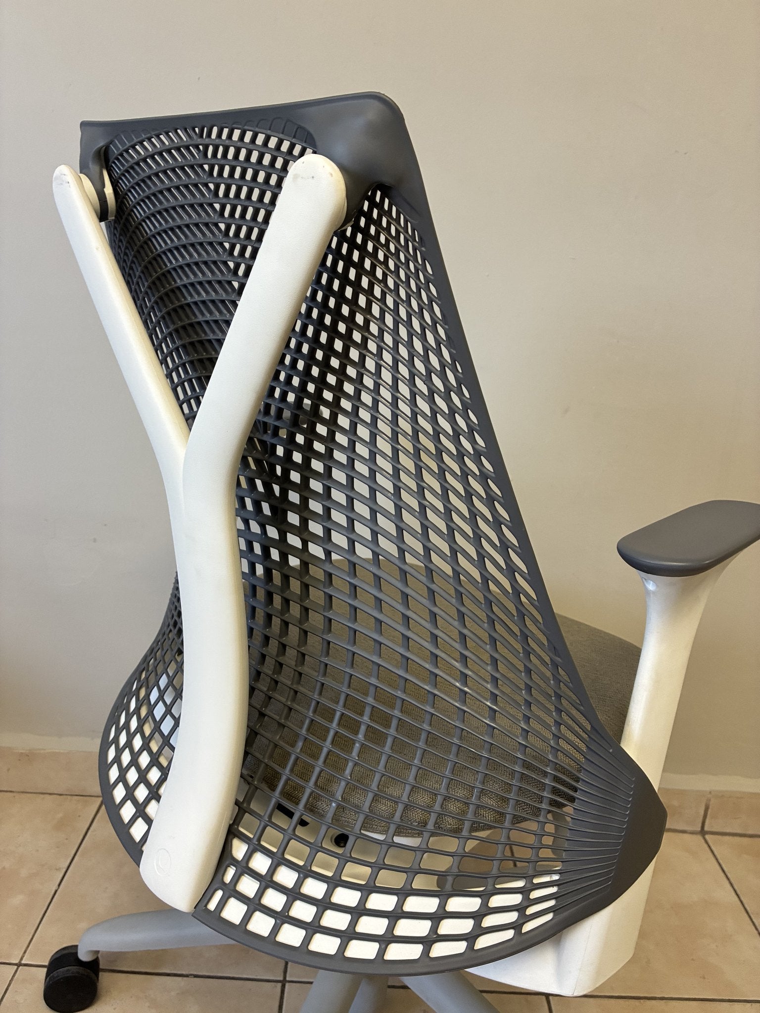 Silla de oficina Herman Miller Sayl preowned, respaldo gris de malla y estructura blanca, vista trasera.