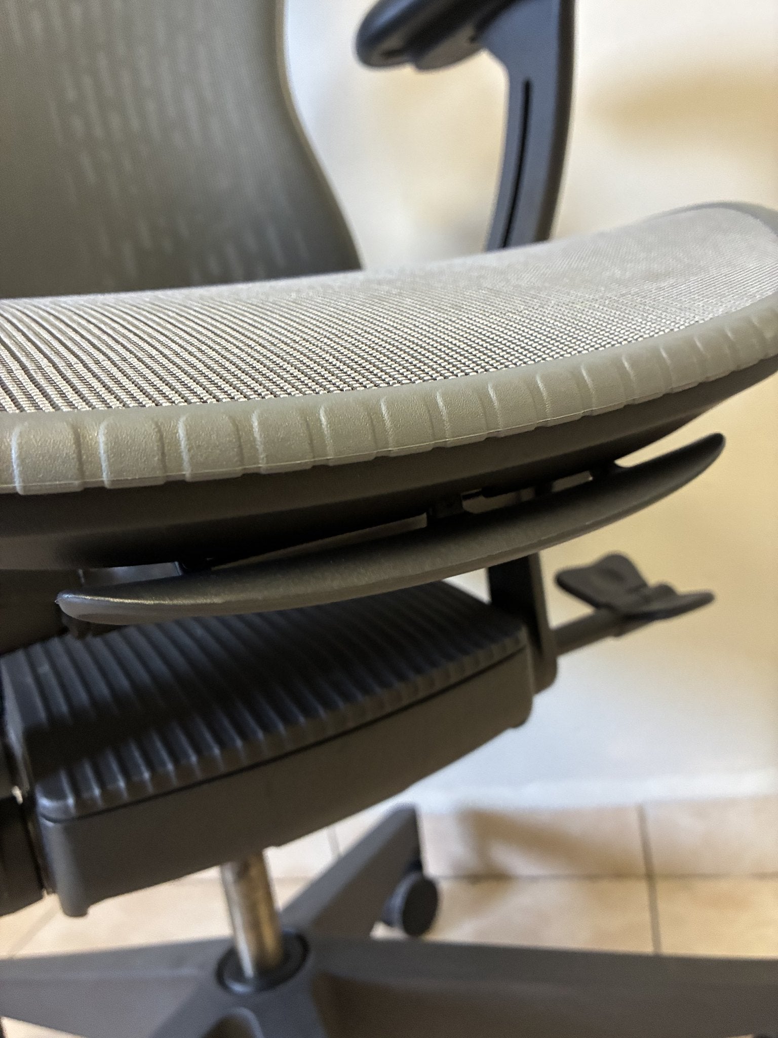 Silla de oficina Herman Miller Mirra 2 Butterfly Equipada, color gris, vista lateral de la base del asiento.