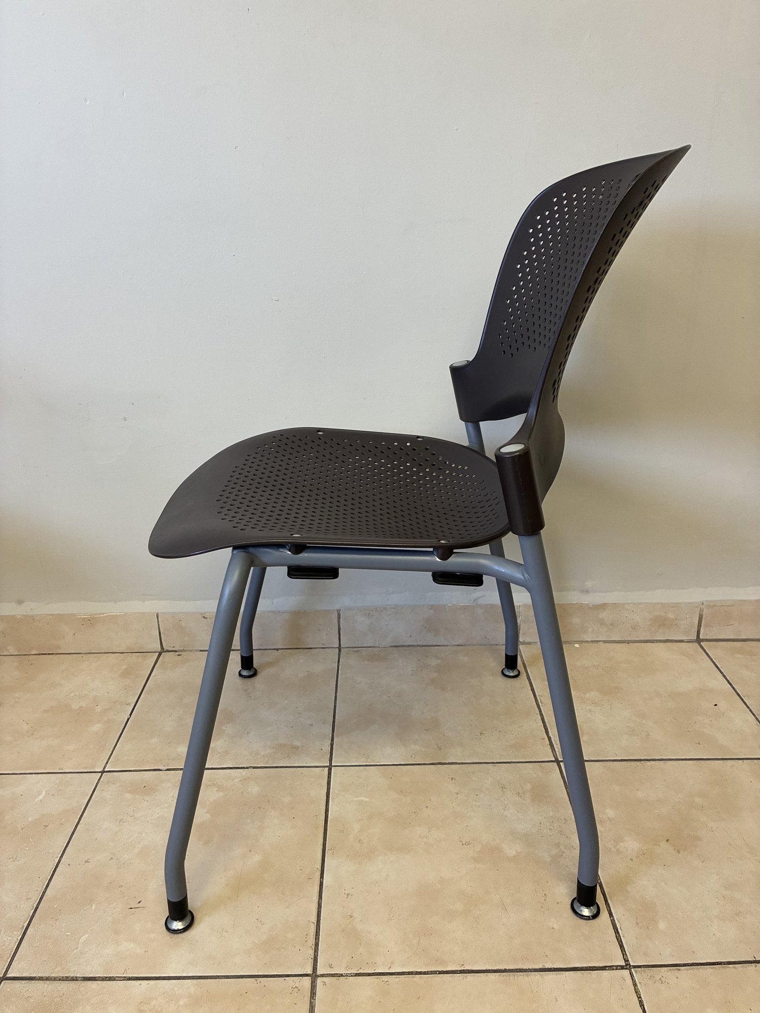 Silla ergonómica Caper de Herman Miller en color café, vista lateral. Asiento y respaldo perforados.