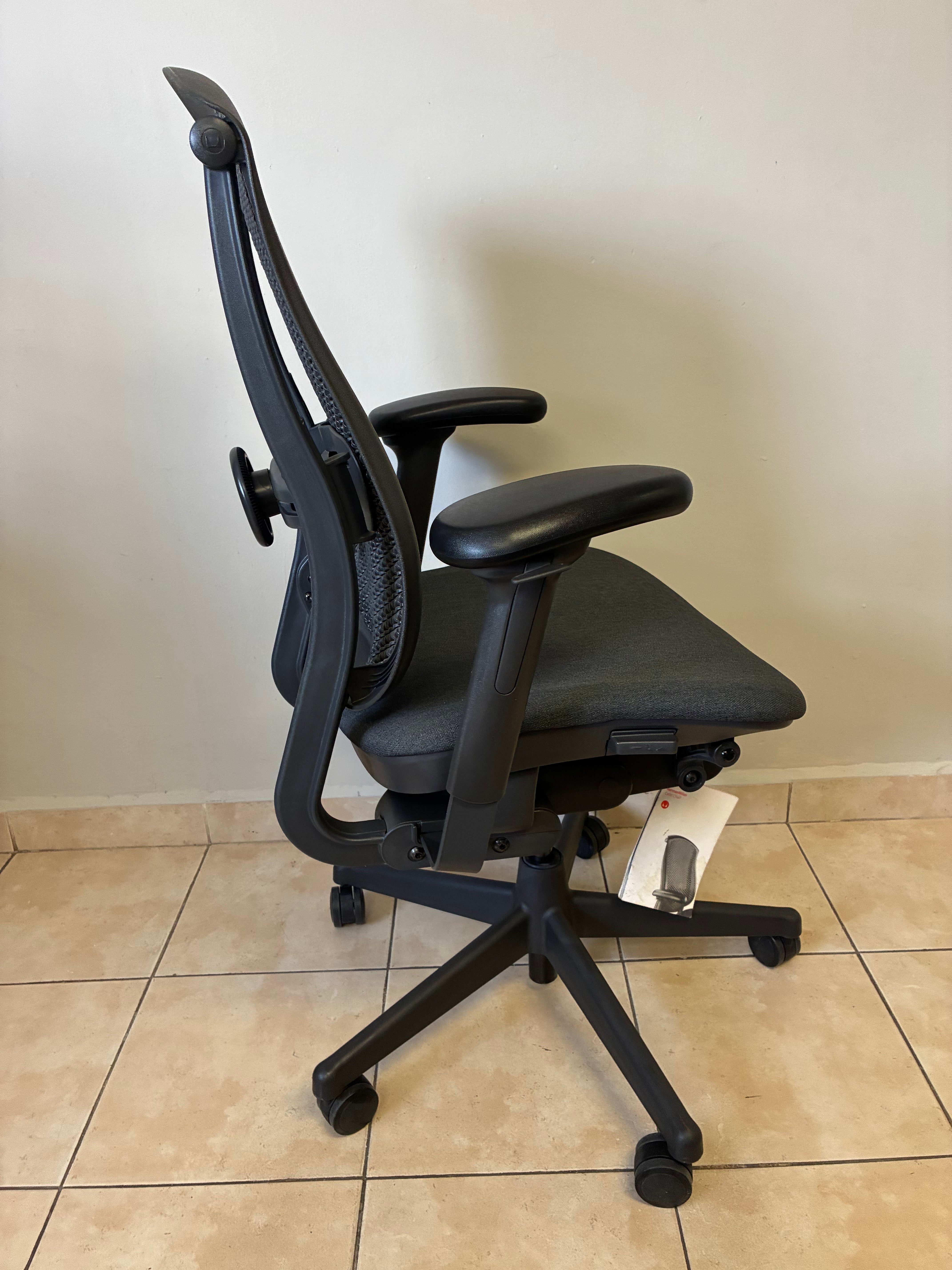 Silla de oficina Herman Miller Celle equipada, color gris oscuro, vista lateral completa