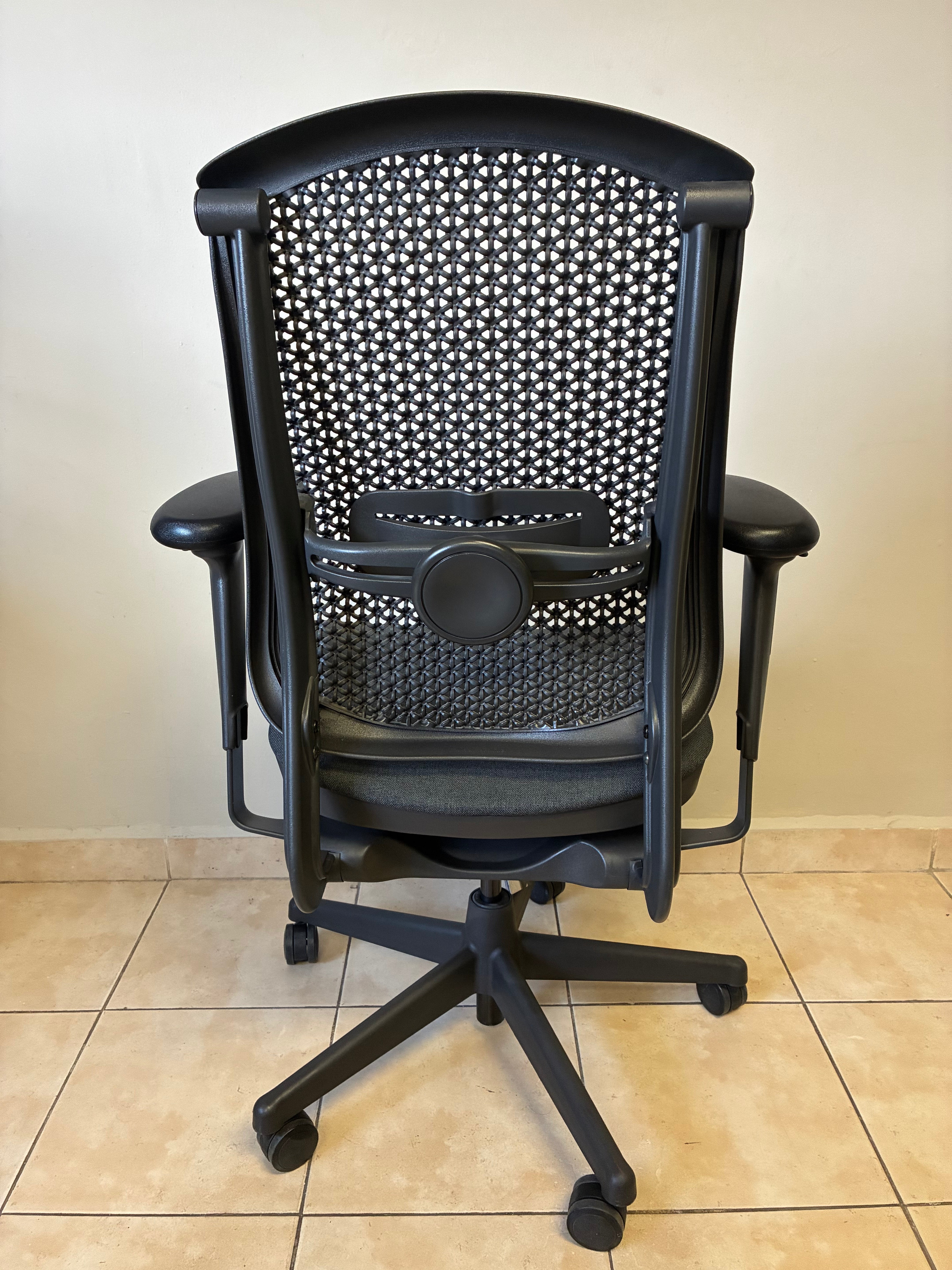 Silla de oficina Herman Miller Celle Equipada, color negro, vista trasera completa con respaldo de malla.