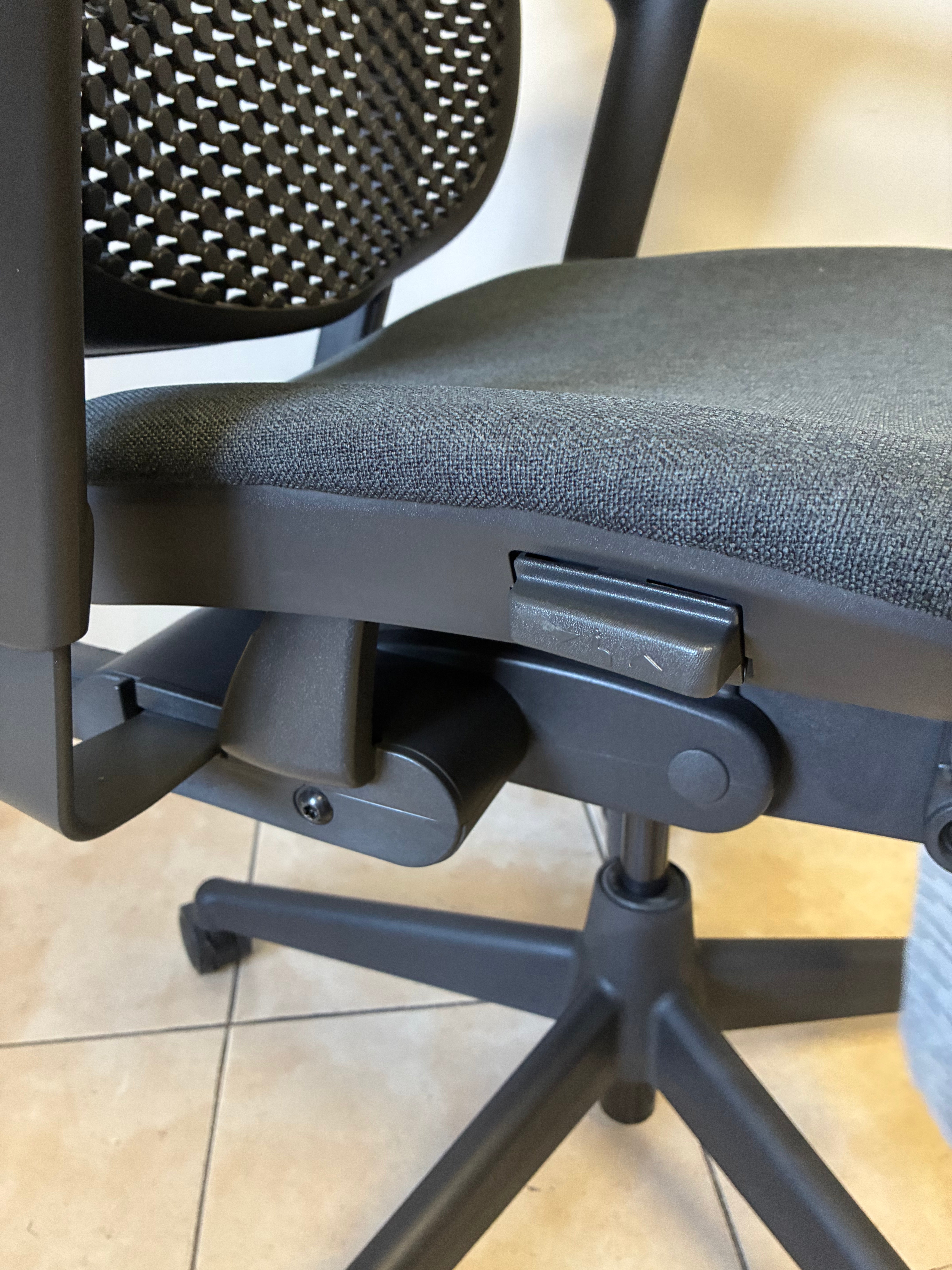 Silla Celle Equipada Herman Miller, sin uso, color gris y negro, vista lateral de los controles de ajuste.