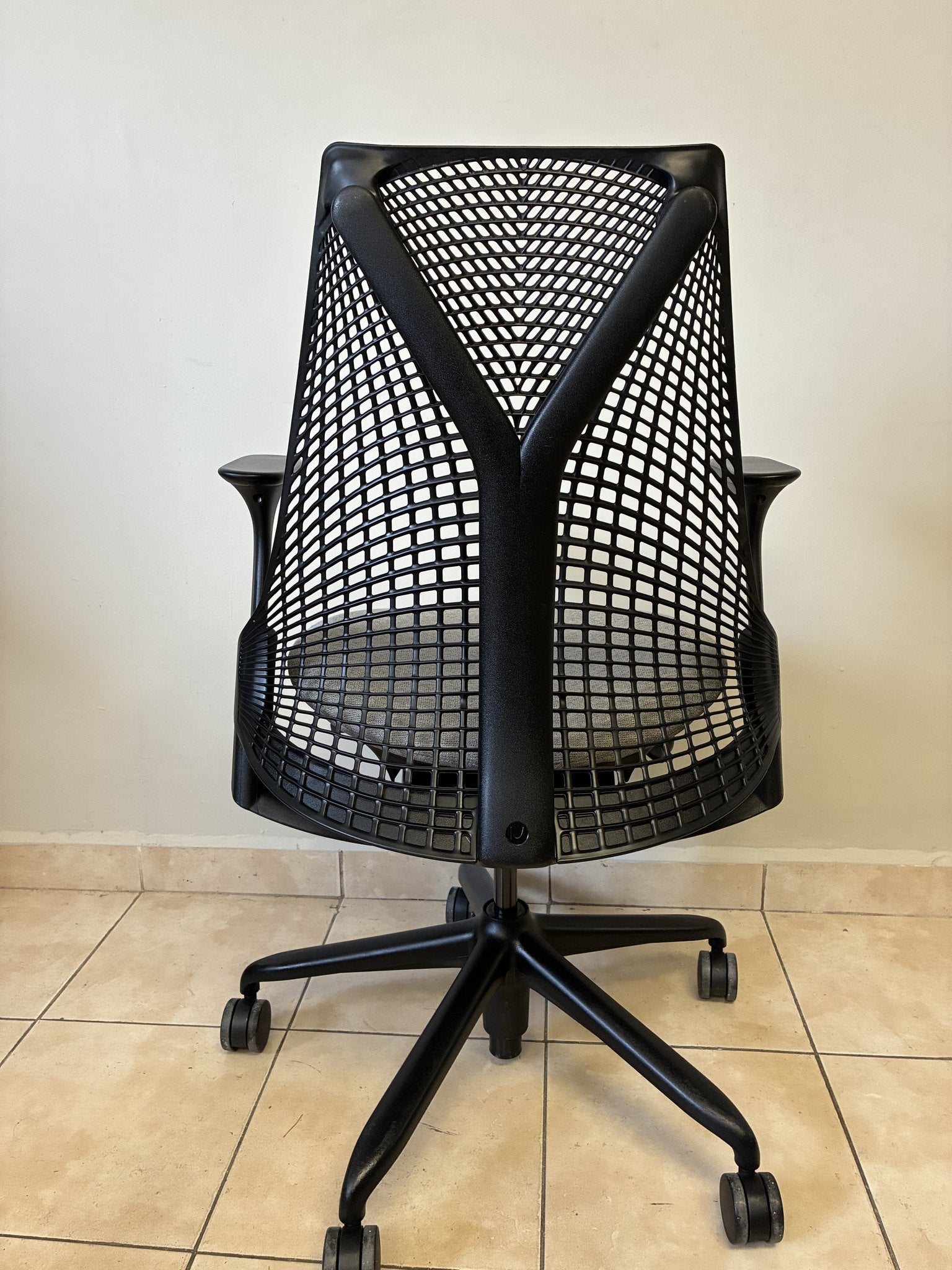 Silla de oficina Herman Miller Sayl preowned, color negro con asiento gris, vista trasera completa.