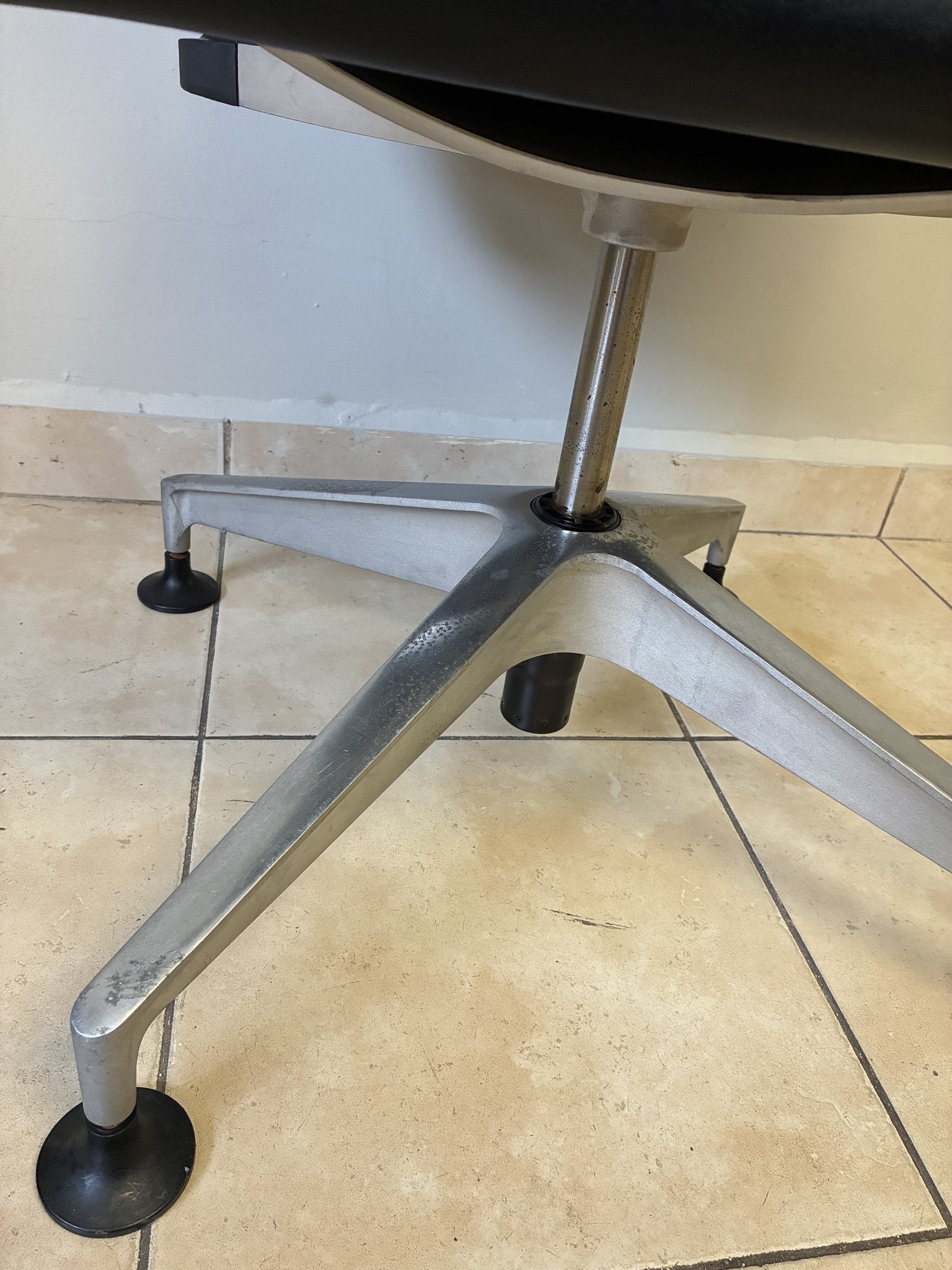Silla de oficina Herman Miller Setu fija preowned, base de aluminio con patas y niveladores negros, vista de cerca.