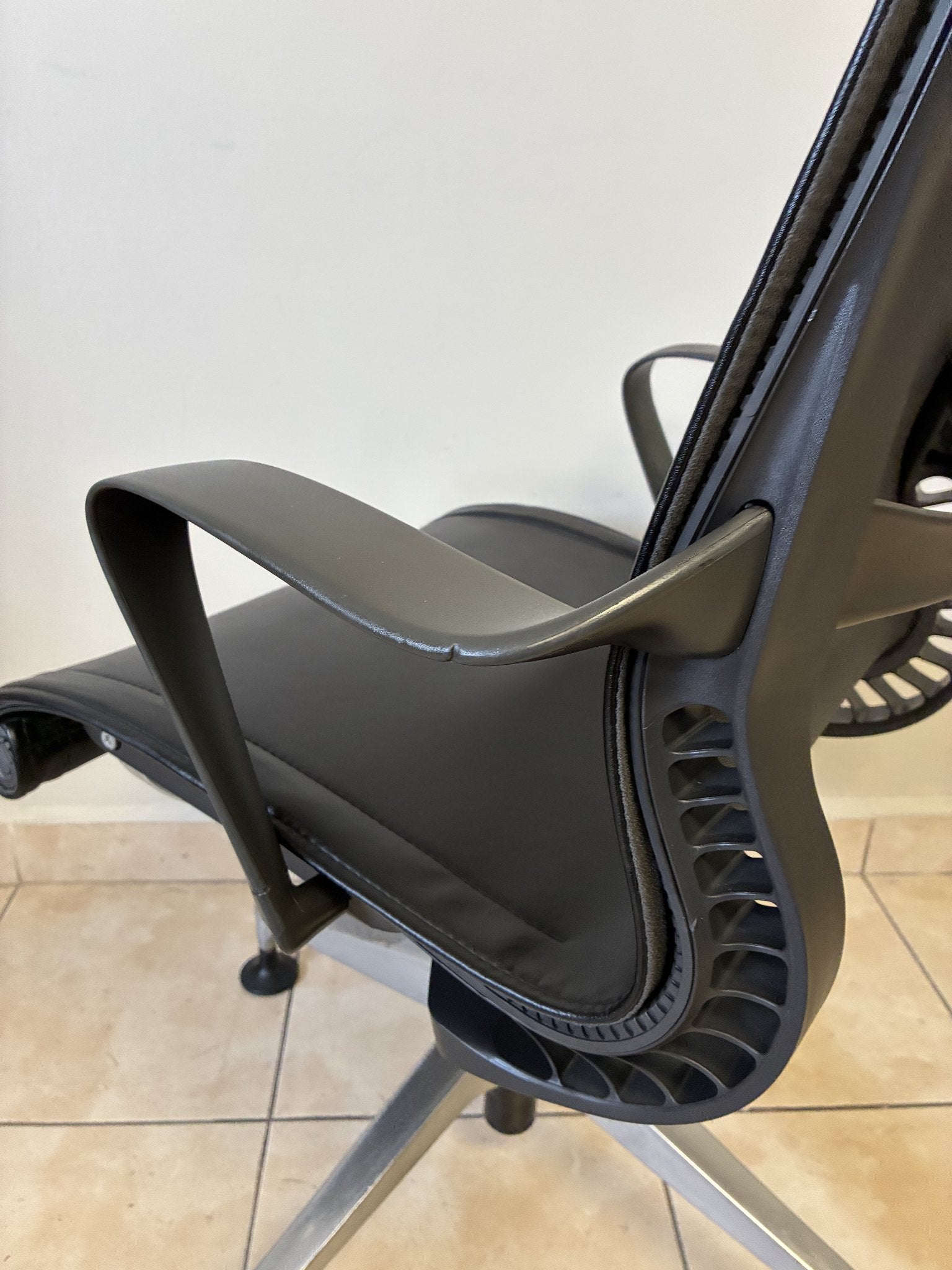Silla de oficina Herman Miller Setu fija preowned, de piel negra, vista lateral del asiento y respaldo.