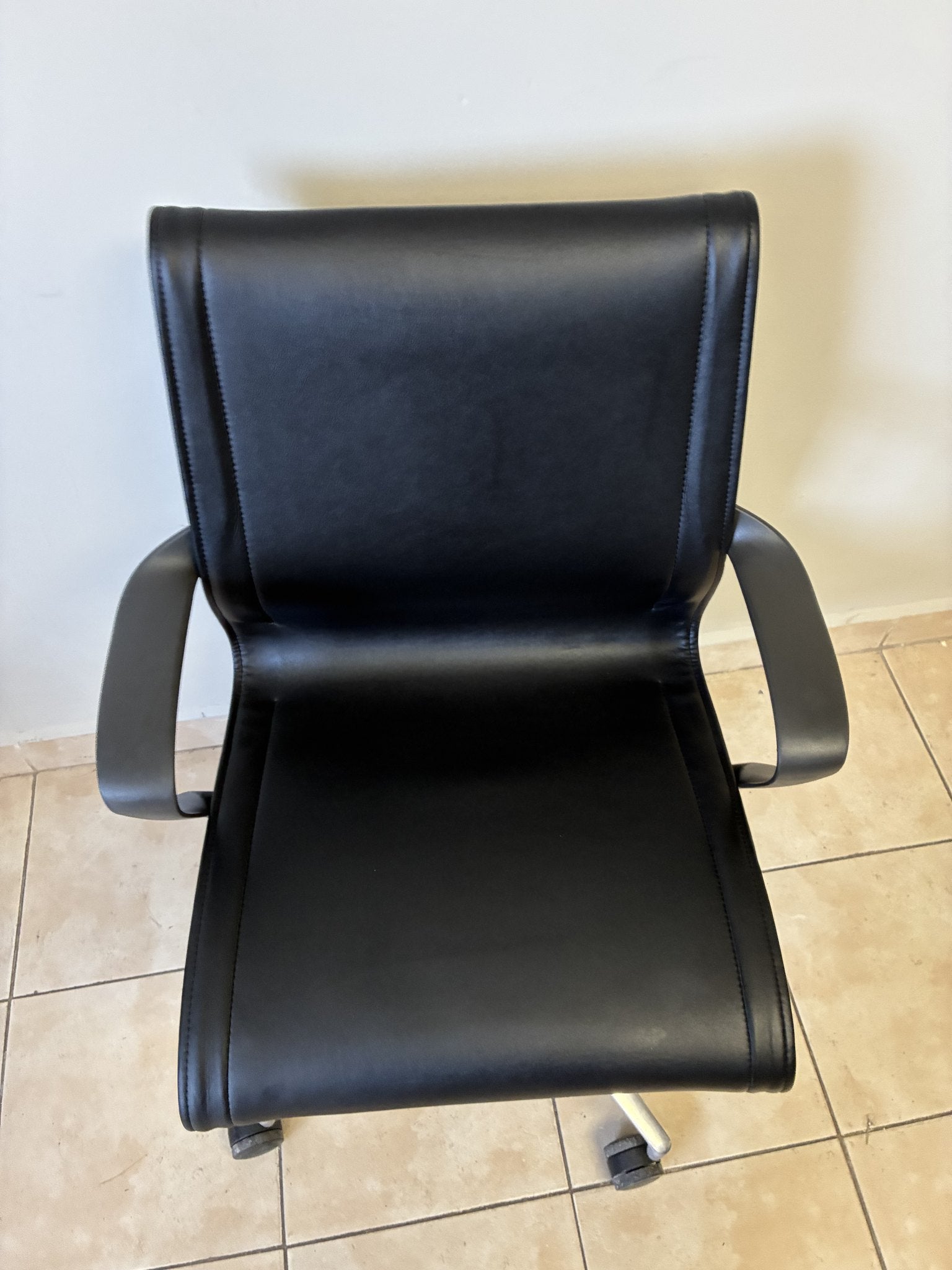 Silla de oficina Herman Miller Setu de piel negra, vista superior frontal, con base de cinco ruedas.