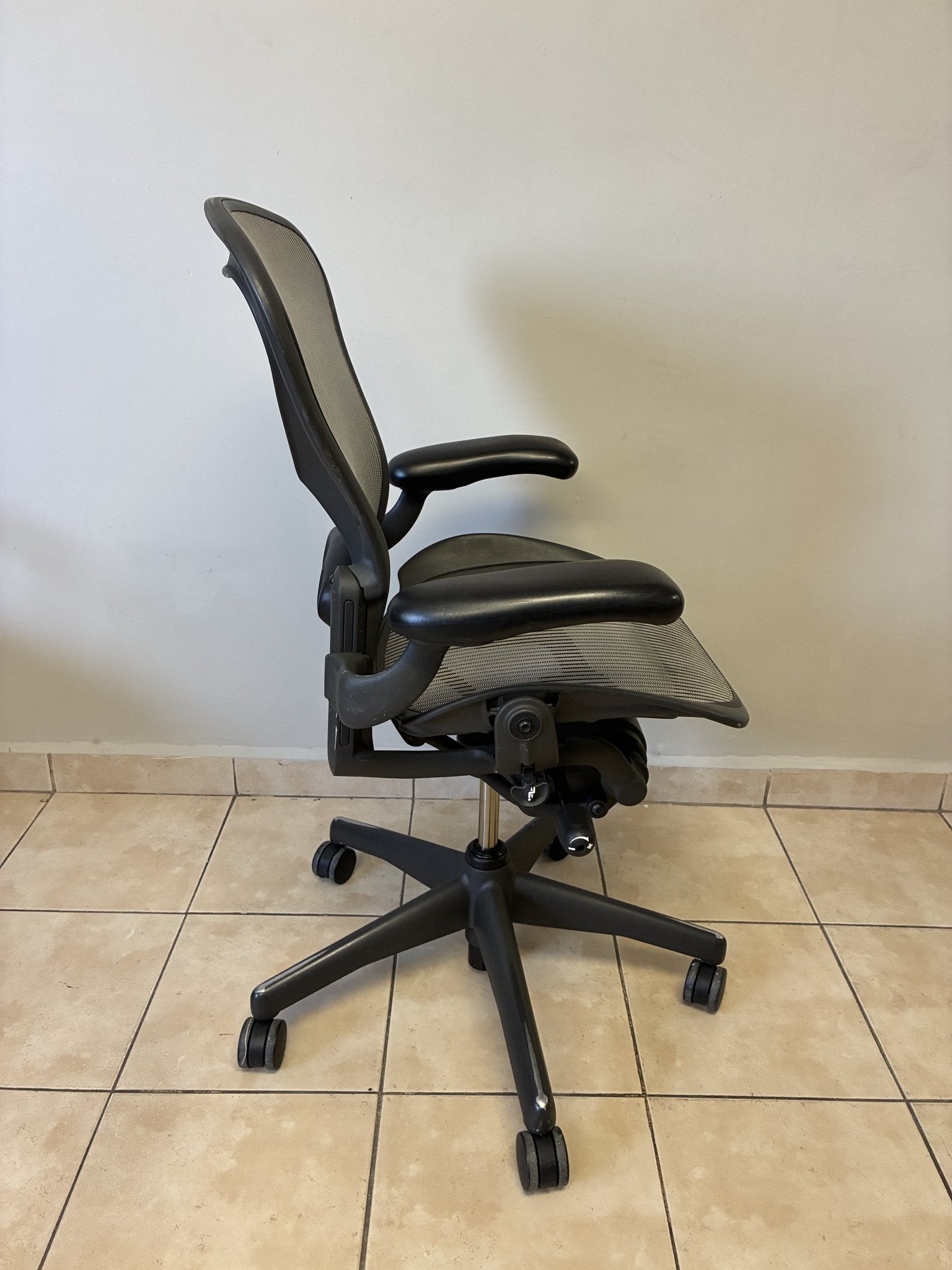 Silla de oficina Herman Miller Aeron Classic Talla B en color grafito y gris, vista lateral.