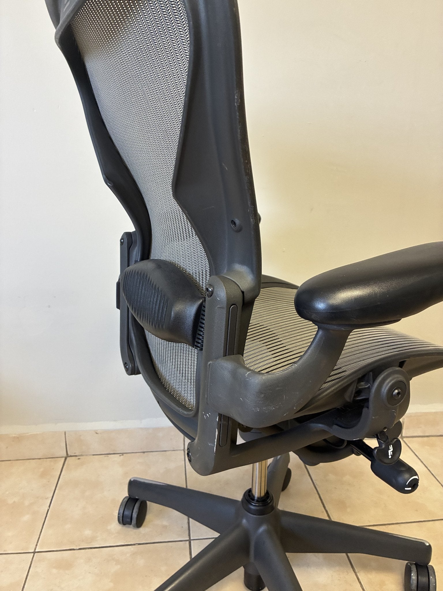 Silla de oficina Herman Miller Aeron Classic Talla B en grafito/gris, vista trasera lateral mostrando el respaldo y.