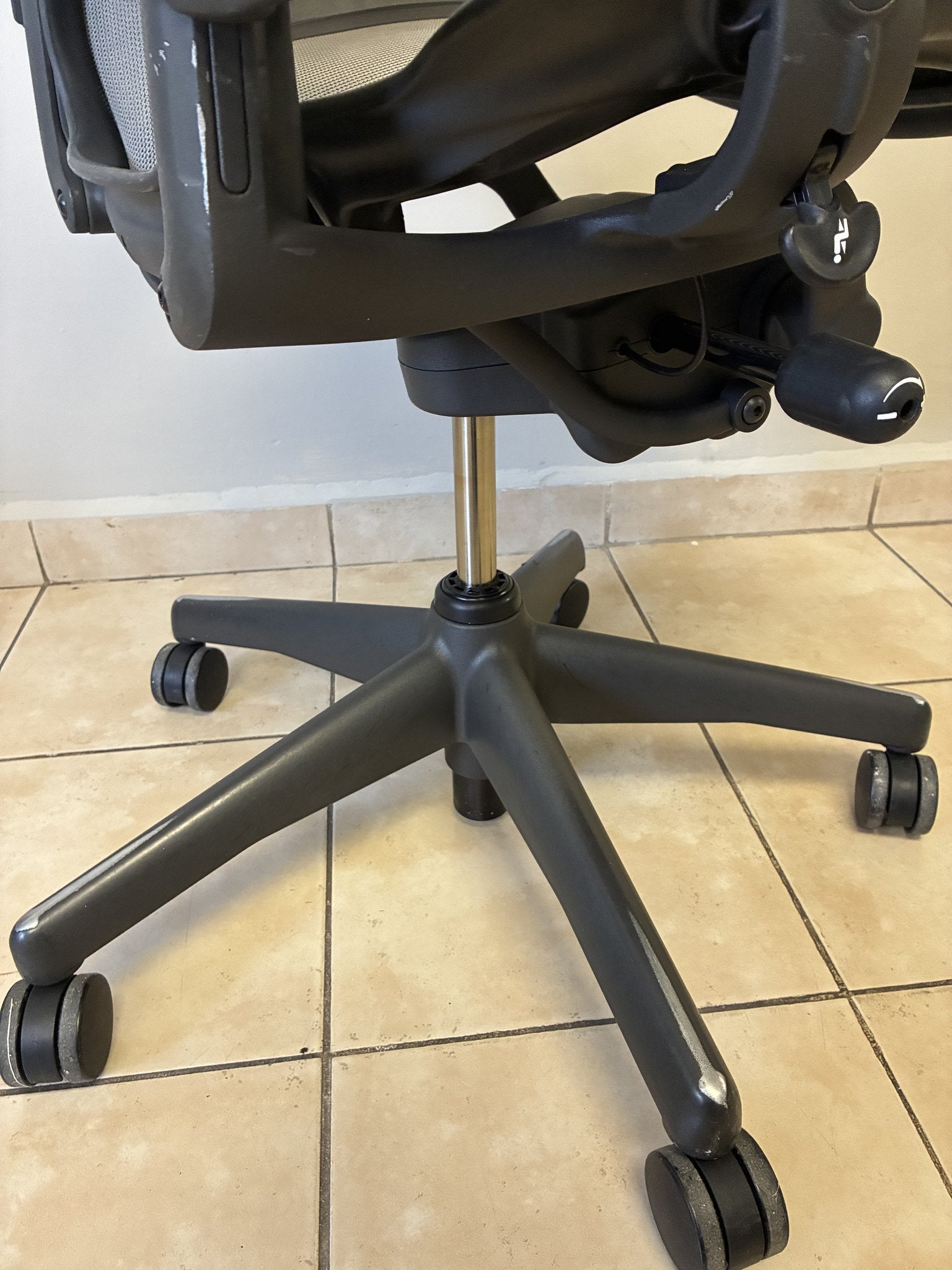 Silla de oficina Herman Miller Aeron Classic Talla B en color grafito/gris, vista de la base con ruedas y mecanismo.