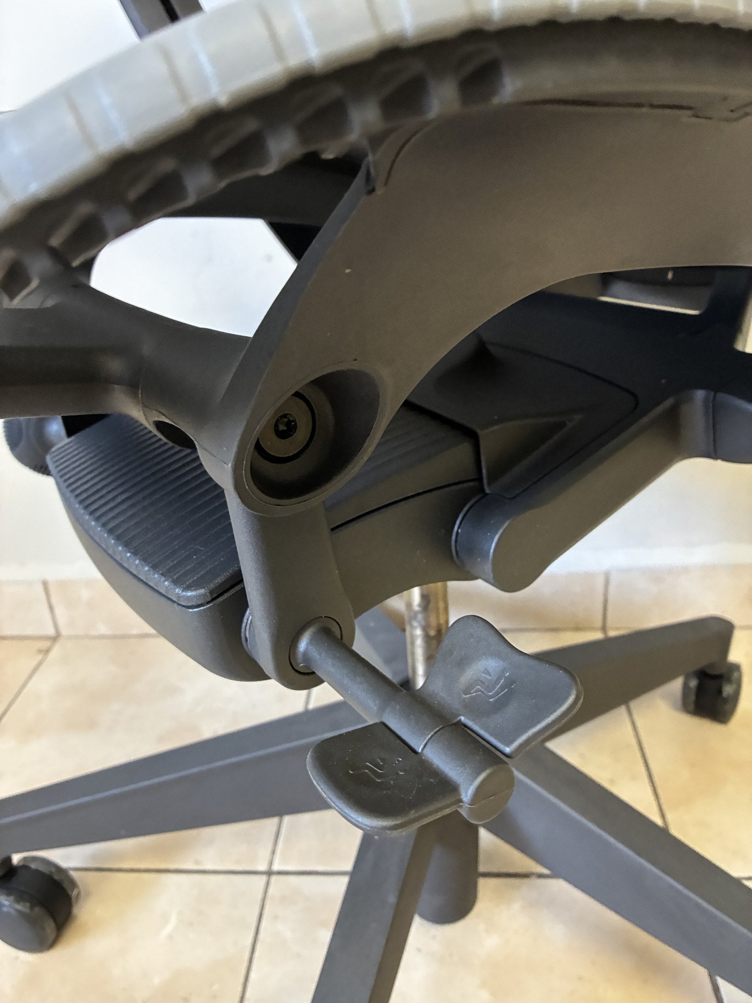 Silla de oficina Herman Miller Mirra 2 Butterfly equipada, color grafito, vista de la base y mecanismos.