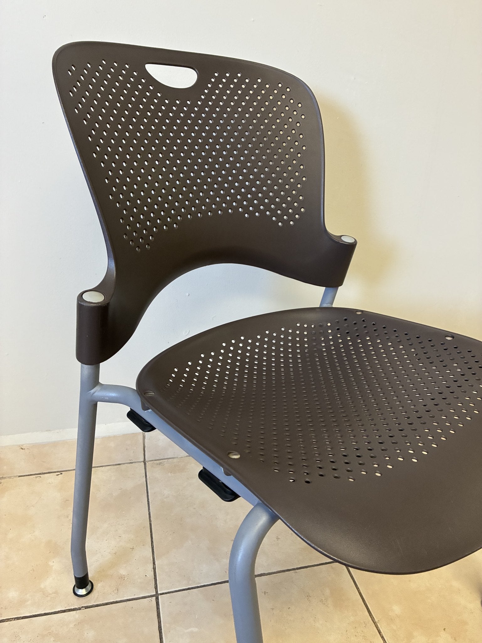 Silla Caper Herman Miller pre-owned, color café, vista lateral. Asiento y respaldo perforados.