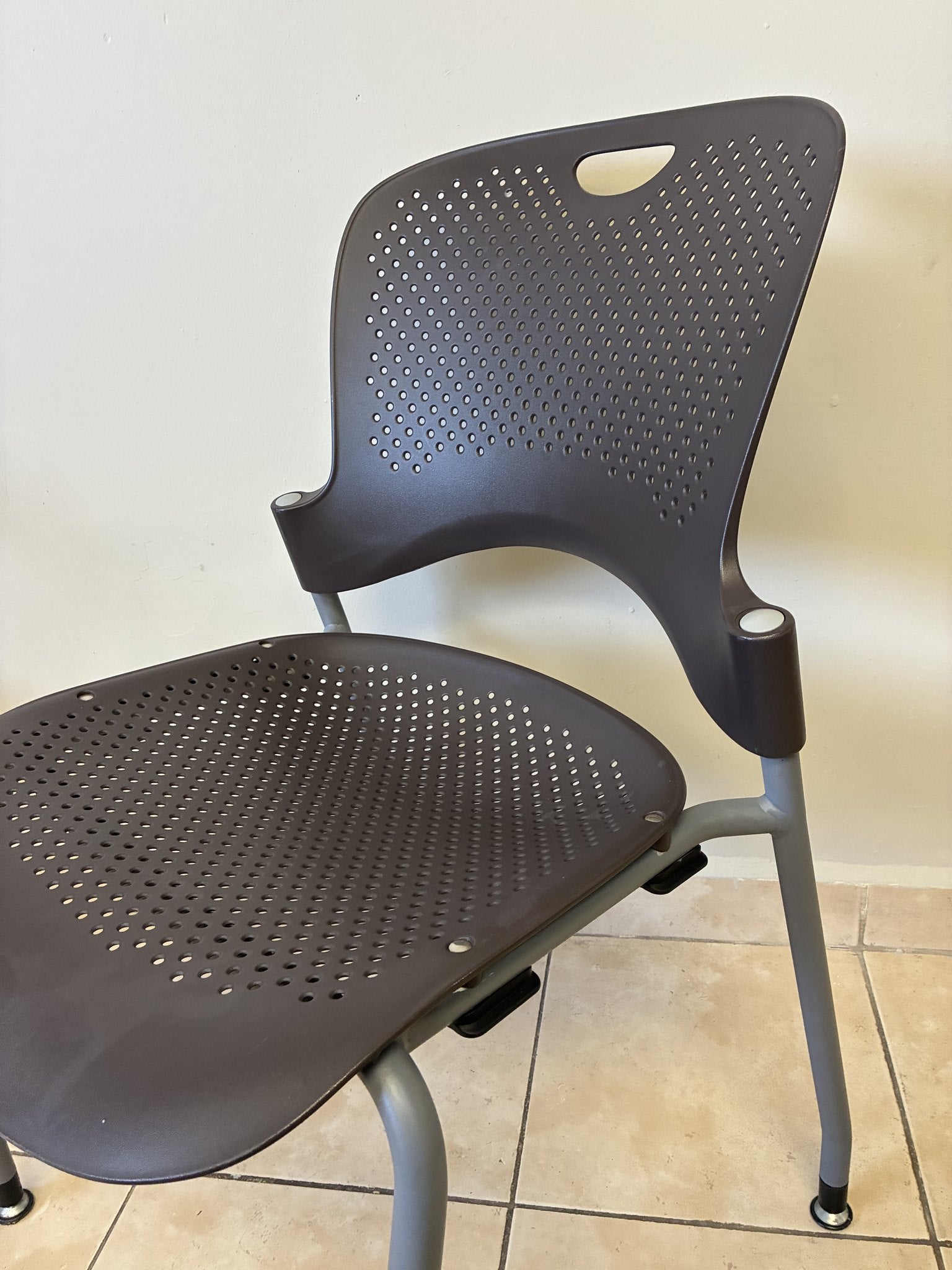 Silla ergonómica Herman Miller Caper café, vista lateral de asiento y respaldo perforados