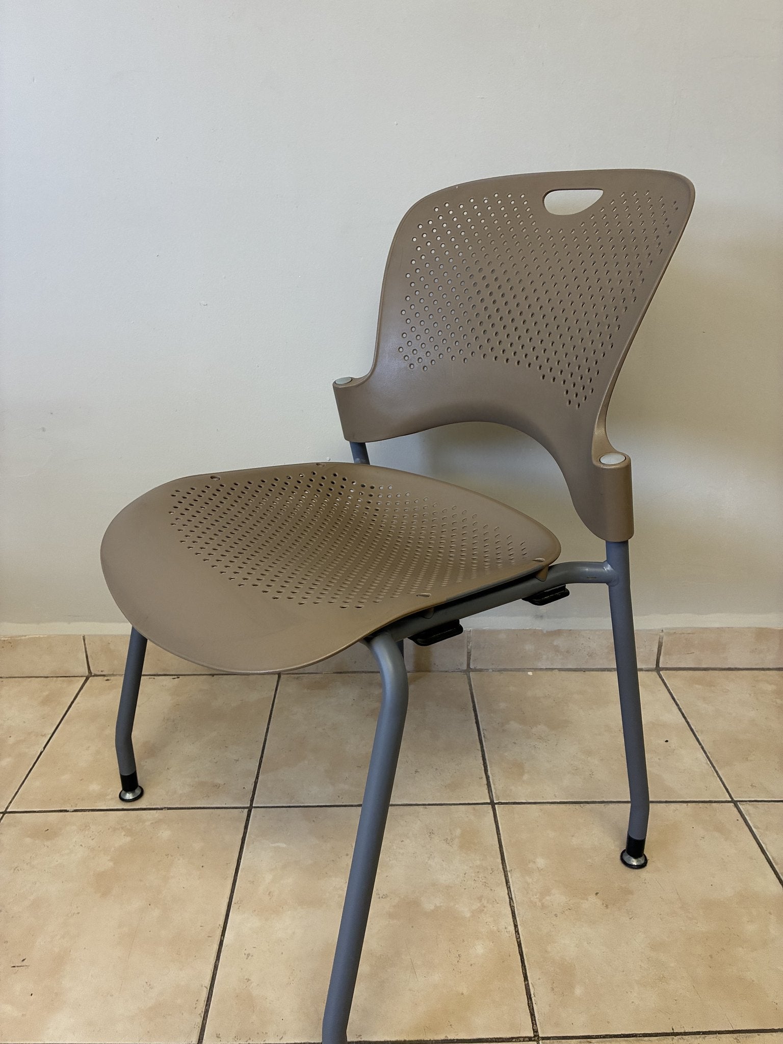 Silla ergonómica Herman Miller Caper pre-owned, color café claro, vista lateral completa, sobre piso de loseta.