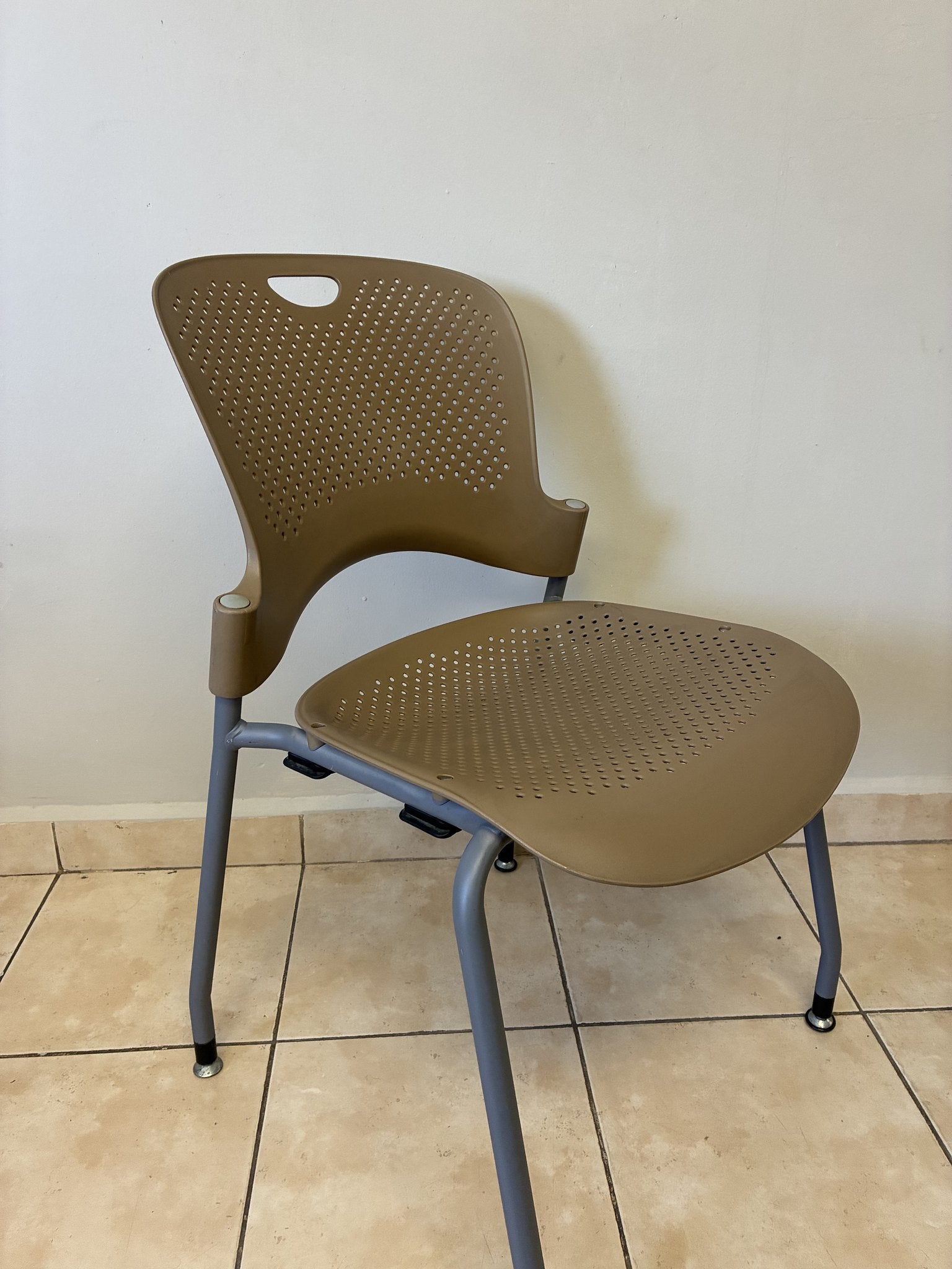Silla ergonómica Herman Miller Caper café claro, vista de tres cuartos, sobre piso de loseta.
