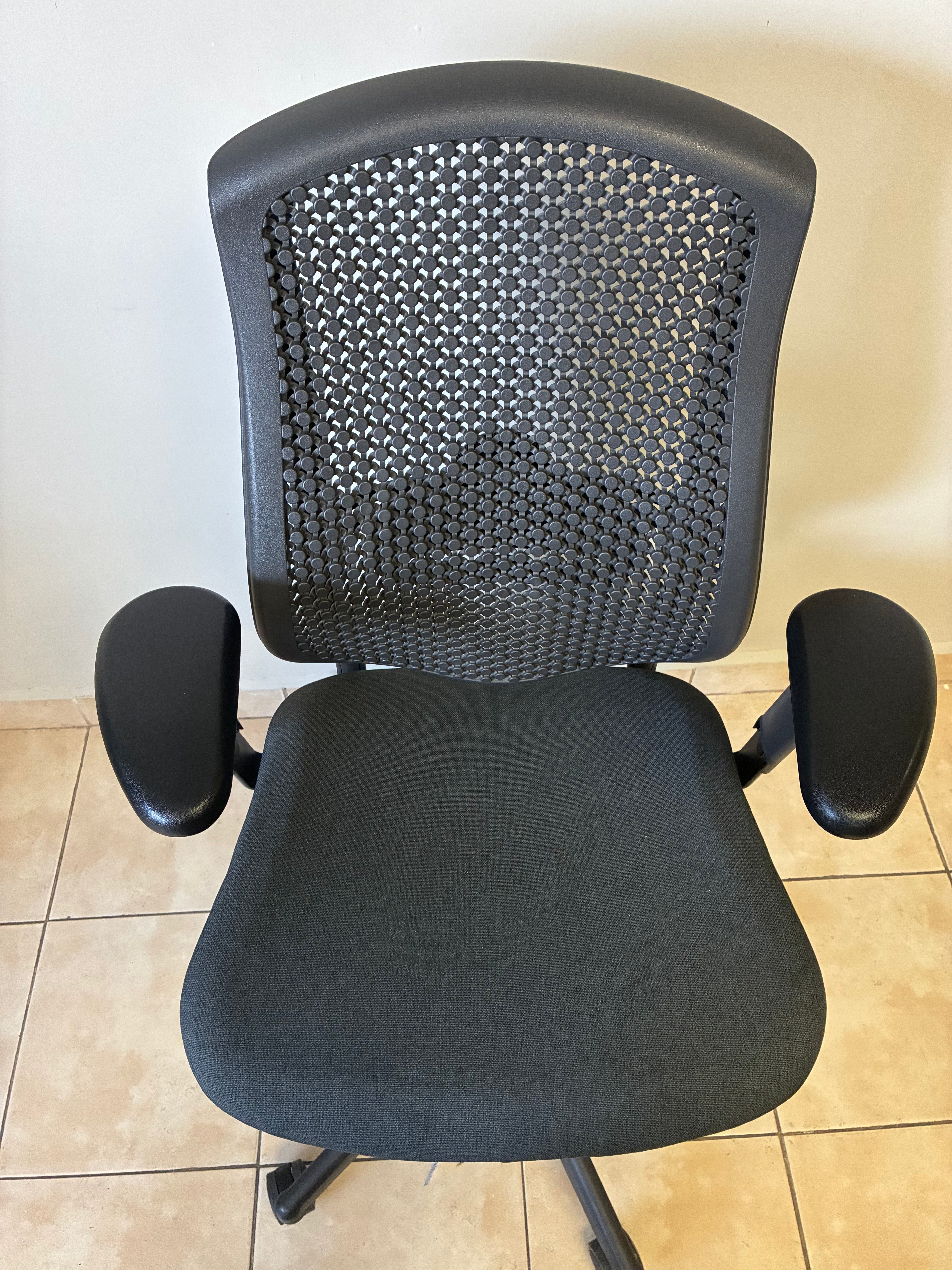Silla de oficina Herman Miller Celle equipada, color negro, vista frontal. Respaldo de malla y asiento de tela.