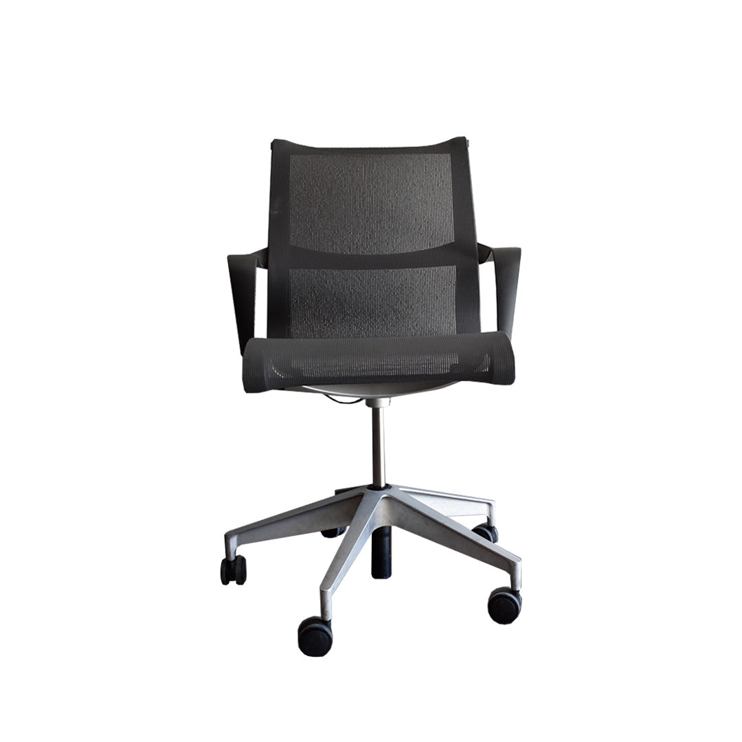 Vista frontal de la silla Setu con brazos gris